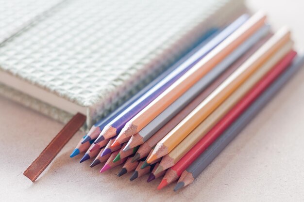 Close-up van gekleurde potloden met dagboek op tafel