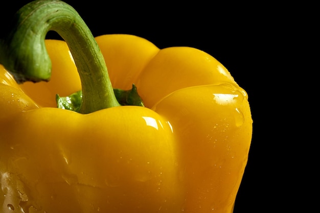 Foto close-up van gele paprika tegen een zwarte achtergrond