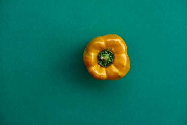 Foto close-up van gele peper tegen een groene achtergrond