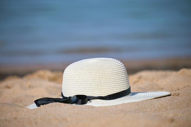 Close-up van gele strohoed op zandstrand aan tropische kust op warme zonnige dag. Zomer vakantie concept.