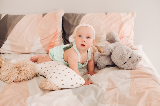 Close up van gelukkig babymeisje liggend op bed met witte pleister op haar bed. Fijne dag thuis