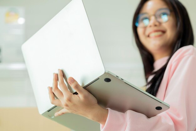 Close-up van gelukkige jonge Aziatische vrouw met laptop