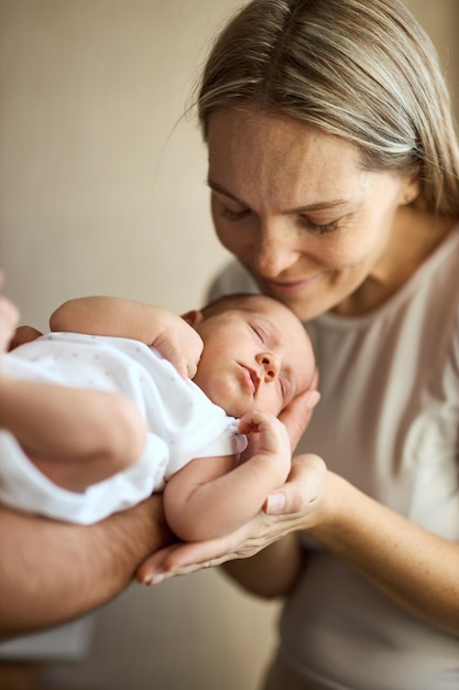 Close-up van gelukkige jonge moeder die pasgeboren baby houdt