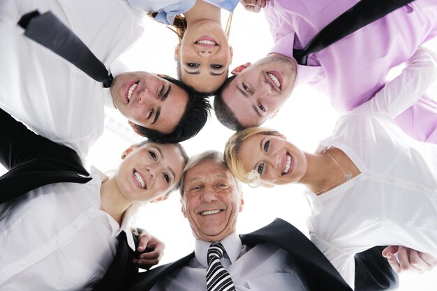Close-up van gelukkige zakenmensen met hun hoofden bij elkaar die het concept van ftiendship en teamwork vertegenwoordigen geïsoleerd op een witte achtergrond