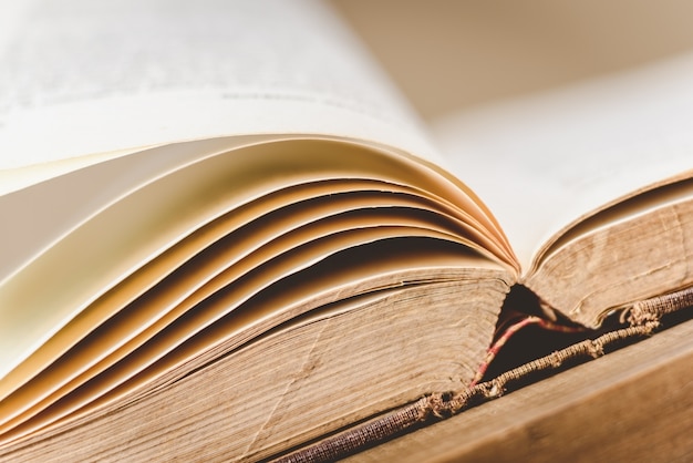 Foto close-up van geopende oude boek op houten tafel