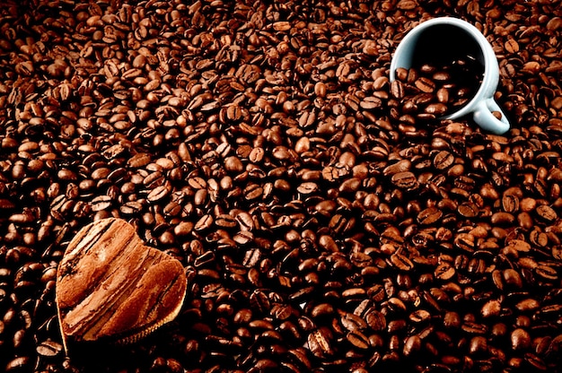 Close-up van geroosterde koffiebonen met kopje