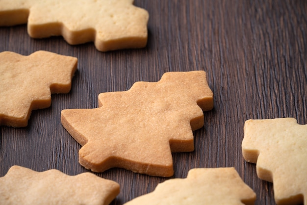 Foto close up van gewone smaak peperkoek kerstboom cookie op houten tafel achtergrond. voedsel voor de viering van de kerstvakantie.