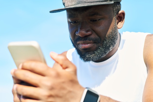 Close-up van gezicht van jonge, bebaarde Afro-Amerikaanse sportman in witte tshirt