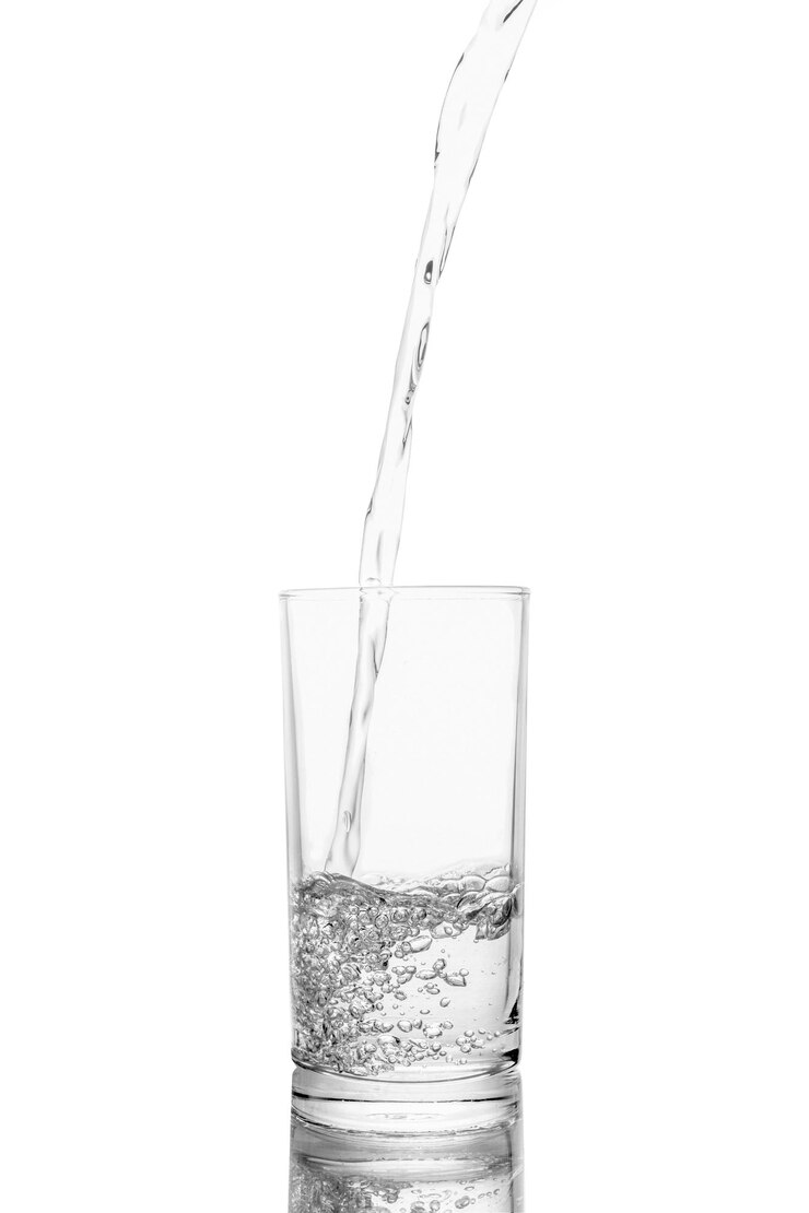 Foto close-up van glas dat water giet op een witte achtergrond