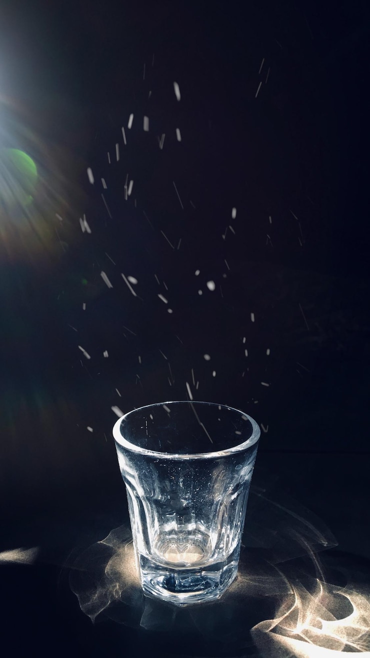 Foto close-up van glas op tafel tegen een zwarte achtergrond