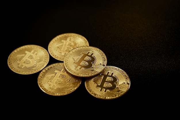 Close up van gouden bitcoin regelen op zwarte achtergrond