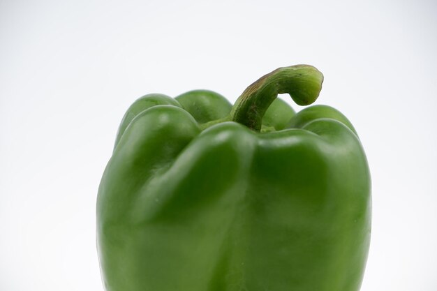 Foto close-up van groene paprika tegen een witte achtergrond