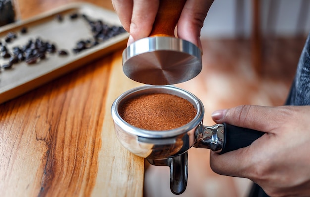 Close-up van hand Barista café koffie maken met sabotage op de houten toonbank in de coffeeshop