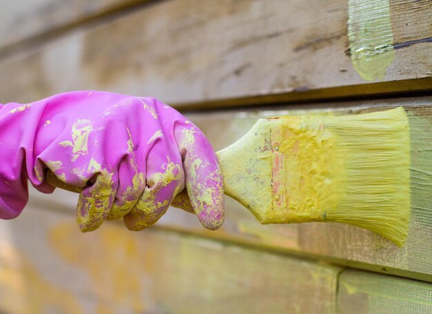 Foto close-up van hand die gele bloemen vasthoudt