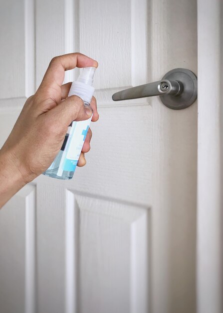 Close-up van hand die witte deur vasthoudt