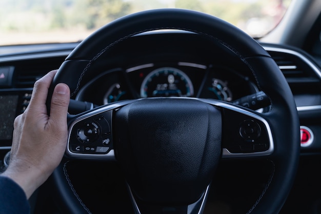 Close up van hand man met stuurwiel in de moderne auto