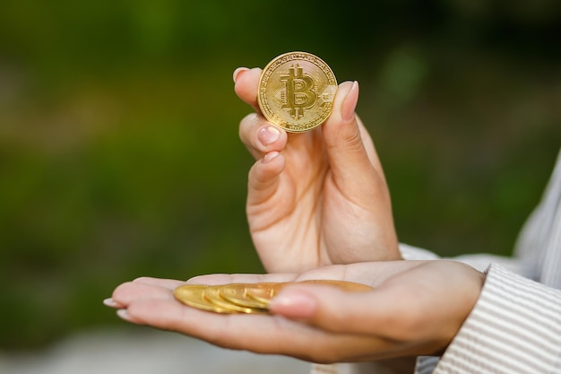 Close-up van hand met gouden bitcoin kopieerruimte voor cryptocurrency commerciële digitale geld elektronische investering Bijgesneden portret van zakenvrouw die bitcoin vasthoudt en het aan de camera laat zien