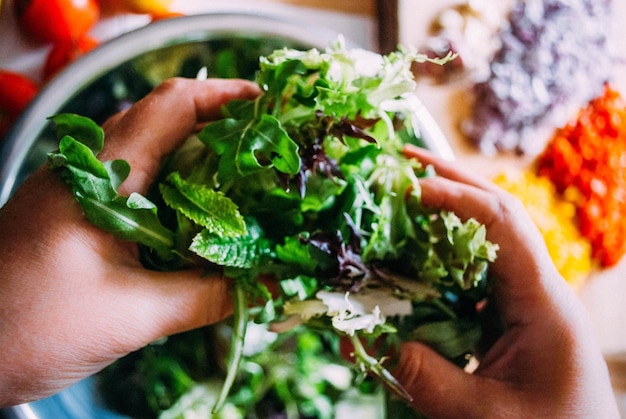 Foto close-up van hand vasthoudende salade