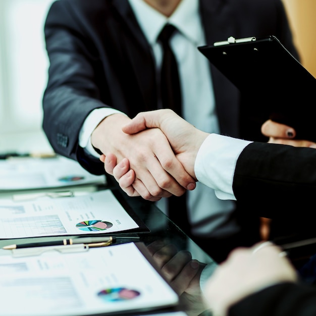 Close-up van handdruk van zakenpartners na bespreking van de financiële overeenkomst