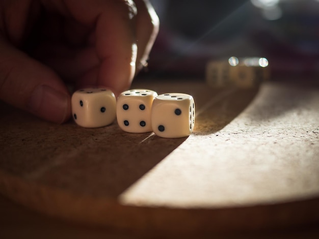 Close-up van handen die op tafel dobbelstenen spelen