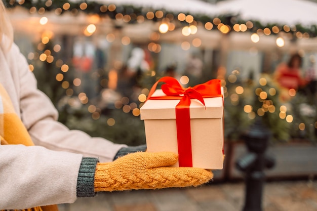 Close-up van handen geven verrassing geschenkdoos cadeau bruin pakket doos met rood lint Vakantie verjaardag Kerstmis concept panoramische banner