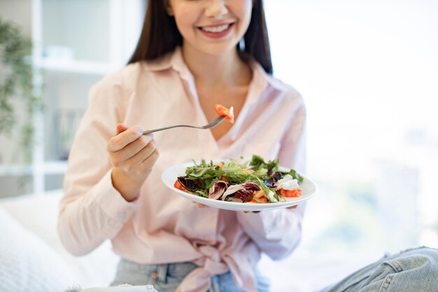 Close-up van handen met salade van blanke vrouw