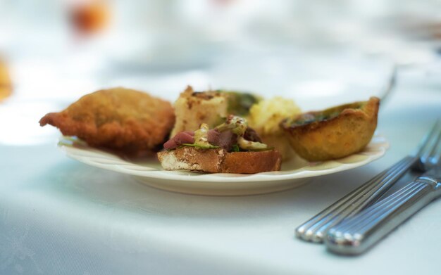 Close-up van hartige snacks geserveerd op porseleinen bord en schotel bij een high tea-evenement of fine dining restaurant Textuurdetail van smakelijke gebaktaarten en antipastobrood met vlees om te eten en te proeven