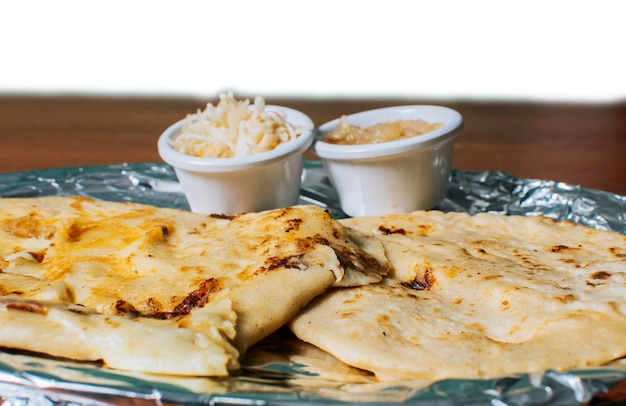 Close up van heerlijke Salvadoraanse pupusas met kaas geserveerd op tafel Traditionele pupusas geserveerd met salade op tafel Twee Nicaraguaanse pupusas met salade op tafel