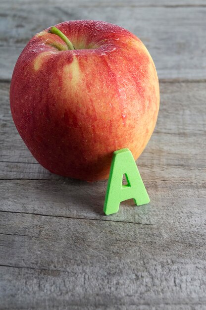 Foto close-up van het alfabet a door appel op tafel