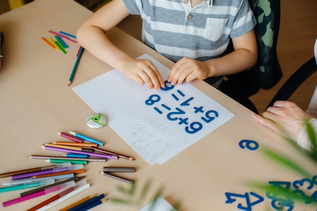 Close-up van het bureaublad waarop ik mijn huiswerk doe, een schooljongen met zijn moeder. Studie.