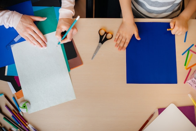 Close-up van het bureaublad waarop ik mijn huiswerk doe, een schooljongen met zijn moeder. Studie.