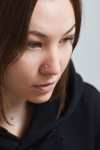 Close-up van het gezicht van een jonge vrouw met piercing die aan haar neus hangt