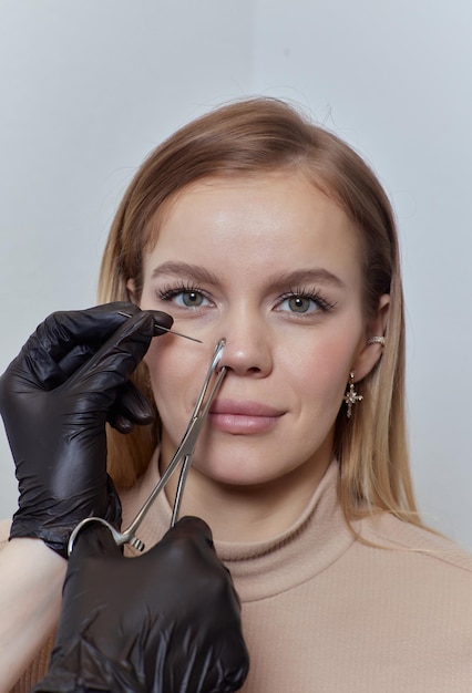 Close-up van het gezicht van een jonge vrouw met piercing die aan haar neus hangt