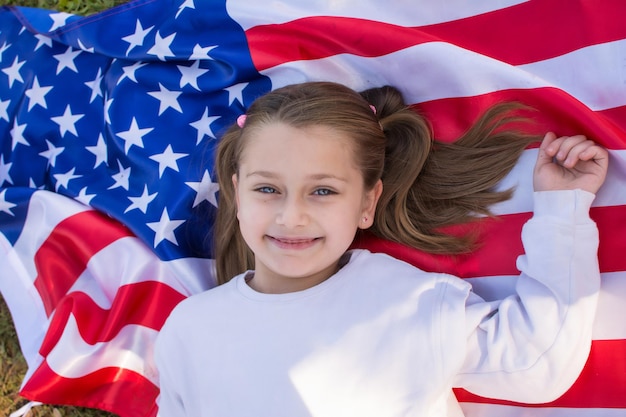 Close-up Van Het Gezicht Van Een Meisje Met De Vlag Van De Verenigde Staten. Ze is blond en heeft blauwe ogen