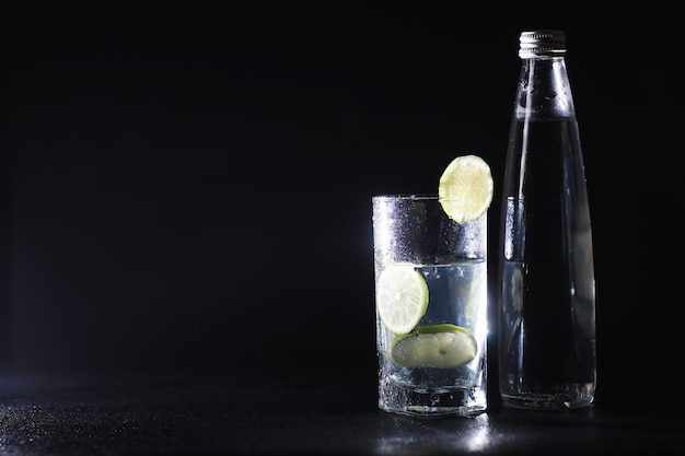 Close-up van het gieten van gezuiverd vers drinkwater uit de fles op tafel in de woonkamer