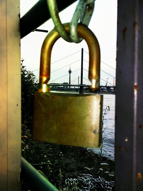 Foto close-up van het hangslot tegen de theodor heuss brug en de rheinturm