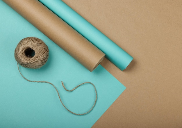 Close-up van het inpakken en inpakken van geschenken met blauw en bruin papier, tafelblad, plat gelegd