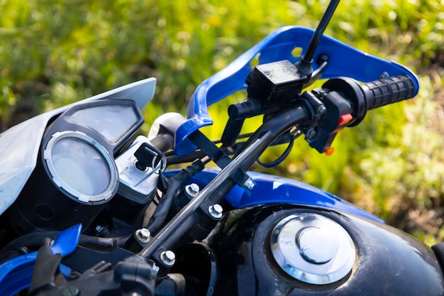 Close-up van het voorwiel van de motorfiets geparkeerd op het gras