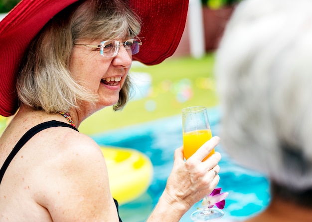 Foto close-up van hogere kaukasische vrouw met sap door de pool