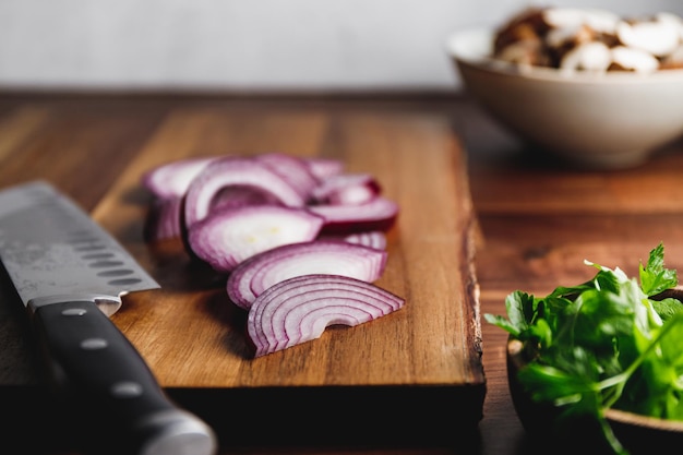 Close-up van houten snijplank mes en ui op een keukentafel Koken concept