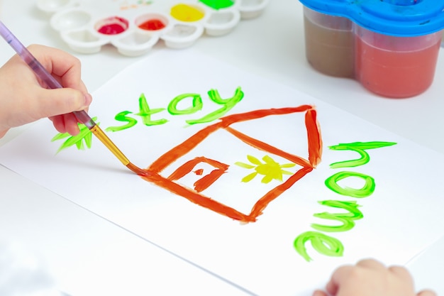 Close-up van huis geschilderd op een wit vel papier met de woorden Stay Home.