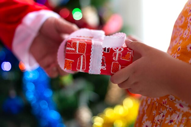 Close-up van iemands handen die een geschenk overhandigen aan een andere kersttijd