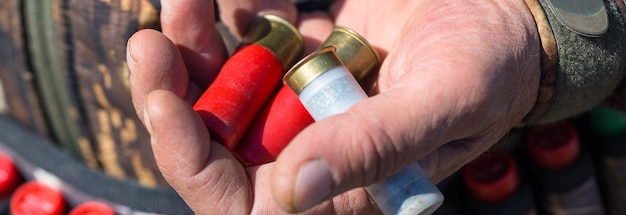 Close-up van jager die jachtgeweer laadt, houdt een pistool en munitie in zijn hand