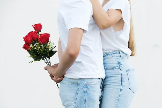 Close-up van jong koppel knuffelen en man met bloemen