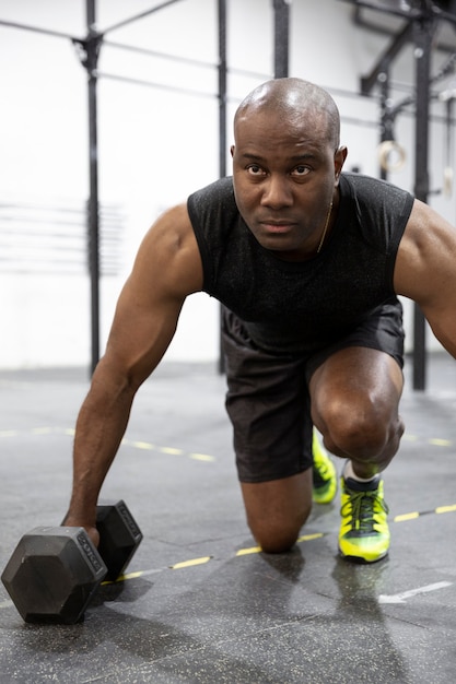 Close up van jonge Afro-Amerikaanse man training in de sportschool. Gezond levensstijlconcept.