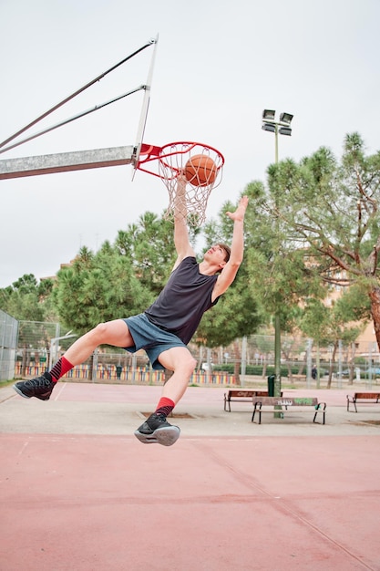 Close up van jonge basketbal straatspeler die slam dunk . maakt