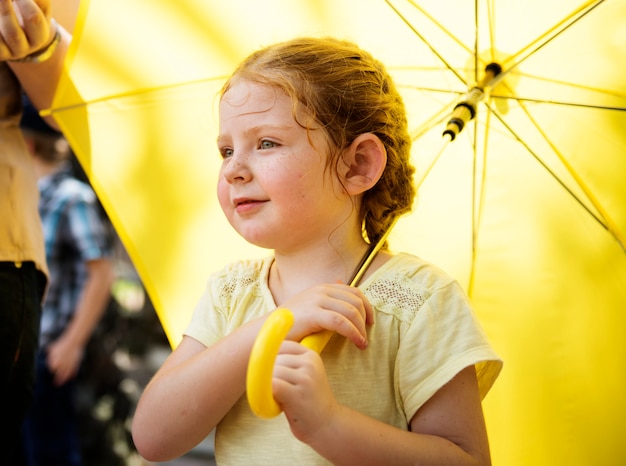 Close-up van jonge blanke meisje met gele paraplu