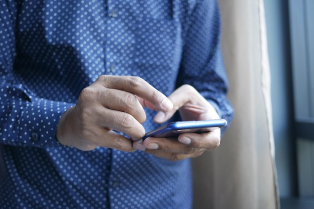 Close up van jonge man hand met behulp van slimme telefoon