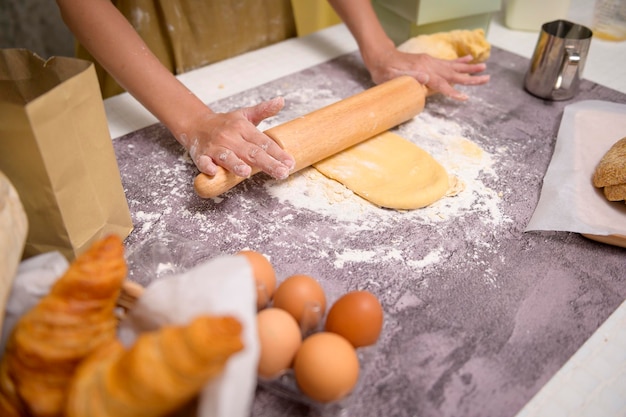 Close-up van jonge mooie vrouw bakt in haar keuken, bakkerij en coffeeshopbedrijf