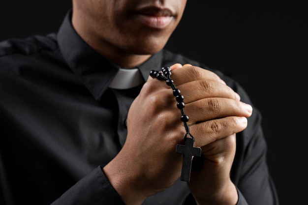 Close-up van jonge priester die binnenshuis bidt